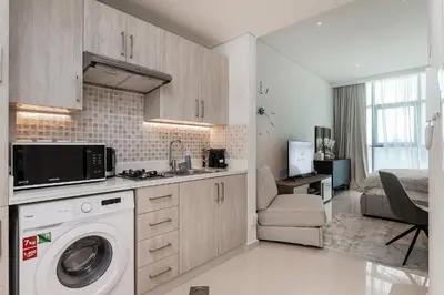 a kitchen with a sink and a washing machine at Popular Seven Palm Apartments in Dubai