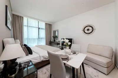 a white room with a bed and a table and chairs at Popular Seven Palm Apartments in Dubai