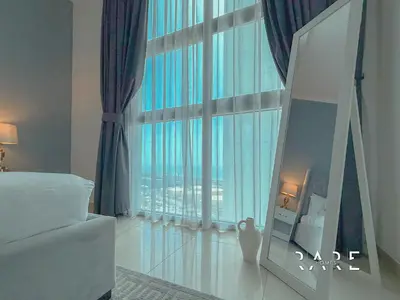 a bedroom with a large window with a view of the city at Rare Holiday Homes - Near Madame Tussauds - DEC Tower 1 - Dubai Marina - R2008 in Dubai