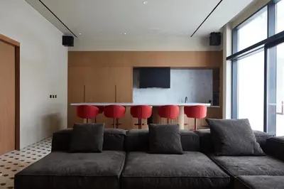 a living room with a couch and red chairs at Modern Studio at Upside Living, Business Bay with Burj Khalifa View in Dubai