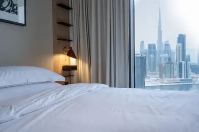 a bedroom with a white bed and a large window at Modern Studio at Upside Living, Business Bay with Burj Khalifa View in Dubai