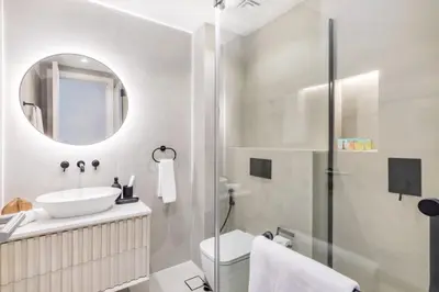 a white bathroom with a sink and a mirror at Luxury Palm Villa with Beach Access -Rooftop Garden & Resort Style Pool by Exclusive Holiday Homes in Dubai