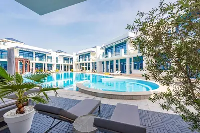 a large swimming pool in front of a building at Luxury Palm Villa with Beach Access -Rooftop Garden & Resort Style Pool by Exclusive Holiday Homes in Dubai