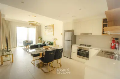 a kitchen and living room with a table and chairs at Stylish 2 BR Apt, Amazing Fountains and Burj Views in Dubai