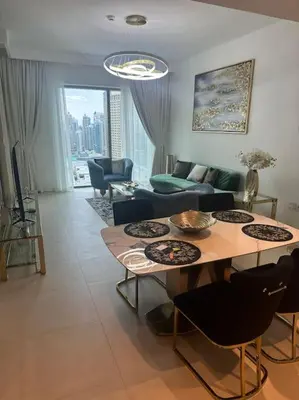 a living room with a table and a couch at Stylish 2 BR Apt, Amazing Fountains and Burj Views in Dubai