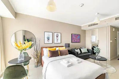 a bedroom with a large bed and a living room at Silkhaus Modern Studio near Almas in West Lake in Dubai