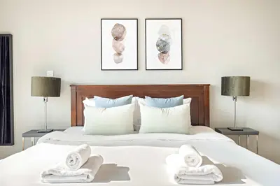 a bedroom with two towels on a bed with two lamps at Silkhaus Modern 1BDR near Almas in East Lake in Dubai