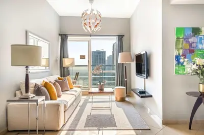 a living room with a couch and a tv at Silkhaus Modern 1BDR near Almas in East Lake in Dubai