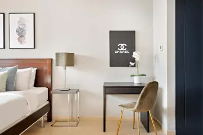 a bedroom with a bed and a desk and a chair at Silkhaus Modern 1BDR near Almas in East Lake in Dubai