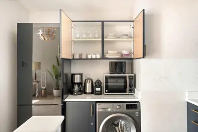 a kitchen with a washing machine and a microwave at Silkhaus Modern 1BDR near Almas in East Lake in Dubai