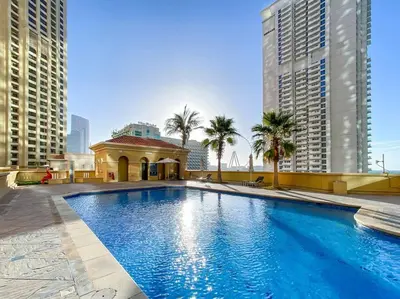 a large swimming pool in a city with tall buildings at Bright 3BR Apartment in JBR Close to Beach & Shops in Dubai