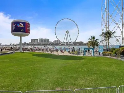 a park with a ferris wheel in the background at Bright 3BR Apartment in JBR Close to Beach & Shops in Dubai