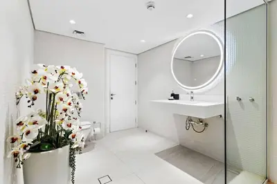 a bathroom with a sink and a toilet and a mirror at Bright 3BR Apartment in JBR Close to Beach & Shops in Dubai