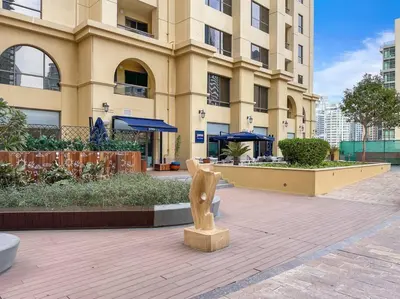 a large building with a statue in front of it at Bright 3BR Apartment in JBR Close to Beach & Shops in Dubai