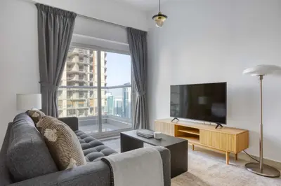a living room with a couch and a flat screen tv at Blueground Marina Pool Gym DXB-221 in Dubai