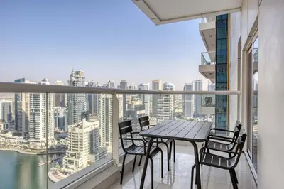 a balcony with a table and chairs and a view of the city at Blueground Marina Pool Gym DXB-221 in Dubai