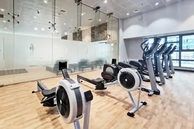 a gym with several treadmills and cardio machines at Blueground Marina Pool Gym DXB-237 in Dubai