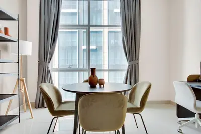 a table and chairs in a room with a window at Blueground Duja Tower City View pool gym DXB-1108 in Dubai