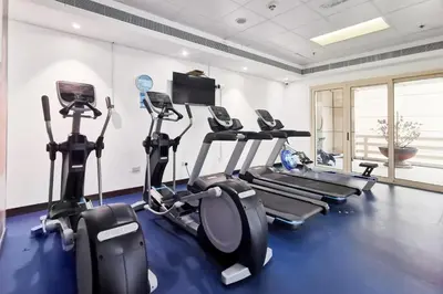 a gym with treadmills and ellipticals in a room at Blueground The Royal Oceanic pool gym DXB-1152 in Dubai