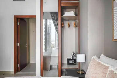 two pictures of a bedroom with a mirror and a bed at Blueground Marina Gate city view sauna gym DXB-1338 in Dubai