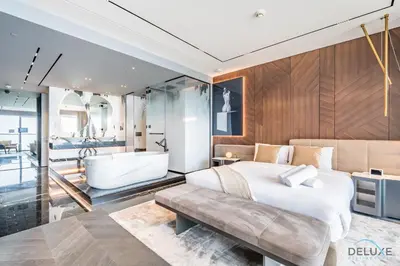 a bedroom with a large bed and a bath tub at Picturesque 3BR with Assistant Room in The One JBR by Deluxe Holiday Homes in Dubai