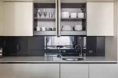 a kitchen with white cabinets and a sink and a counter at Blueground DIFC indoor pool fitness center DXB-1515 in Dubai
