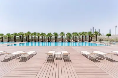 a swimming pool with tables and chairs next to a pool at Blueground DIFC Burj K view pool fitness DXB-1535 in Dubai