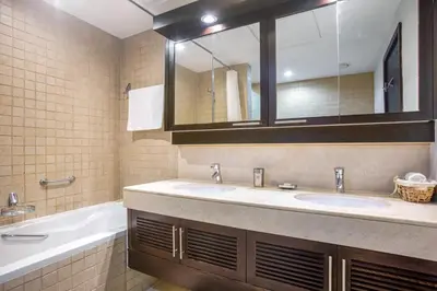 a bathroom with two sinks and a tub and a mirror at Blueground Downtown B Khalifa view pool DXB-645 in Dubai