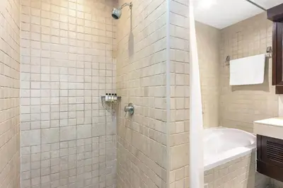 a bathroom with a shower with a tub and a sink at Blueground Downtown B Khalifa view pool DXB-645 in Dubai