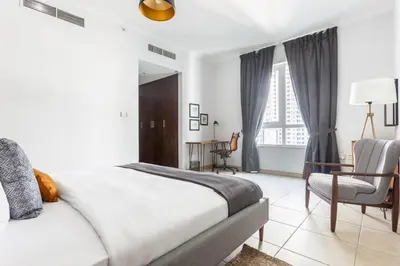 a bedroom with a bed and a desk and a chair at Blueground Downtown B Khalifa view pool DXB-645 in Dubai