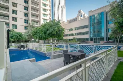 a balcony with a table and a swimming pool at BellaVista - 29 Boulevard 2 Bedroom Downtown Fountain View in Dubai