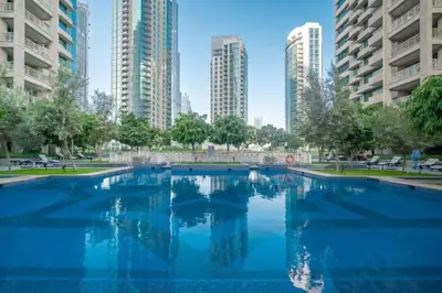 a large swimming pool in a city with tall buildings at BellaVista - 29 Boulevard 2 Bedroom Downtown Fountain View in Dubai