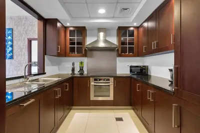a large kitchen with wooden cabinets and a sink at BellaVista - 29 Boulevard 2 Bedroom Downtown Fountain View in Dubai