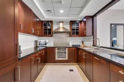 a large kitchen with wooden cabinets and a sink at Bellavista 1 Bedroom Full Burj Khalifa View 29 Boulevard Downtown Dubai in Dubai