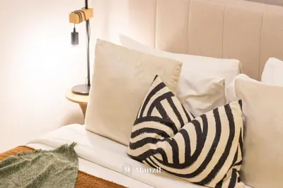 two zebra pillows sitting on a white couch at Manzil - Studio in JVC w Premium Amenities near Circle Mall in Dubai