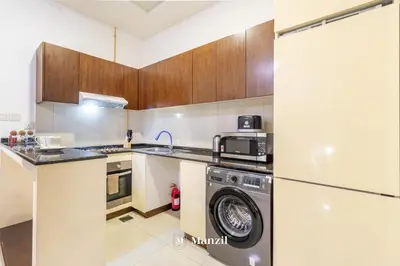 a kitchen with a washing machine and a washer at Manzil - Studio in JVC w Premium Amenities near Circle Mall in Dubai