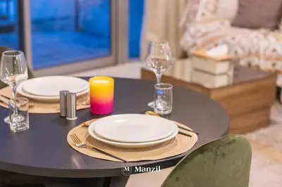 a black table with plates and glasses and a candle at Manzil - Studio in JVC w Premium Amenities near Circle Mall in Dubai