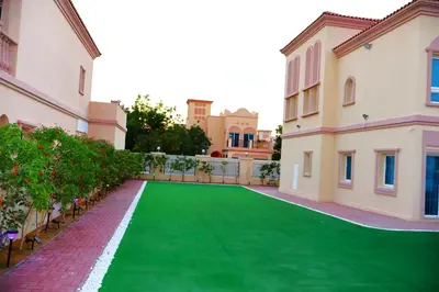 a green lawn in the courtyard of a building at Fully Furnished Garden Villa 2 Bedroom in Dubai