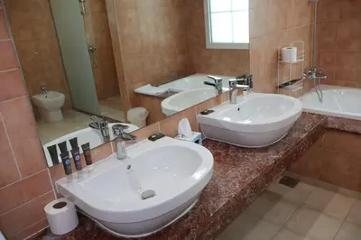 a bathroom with two sinks and a large mirror at Fully Furnished Garden Villa 2 Bedroom in Dubai