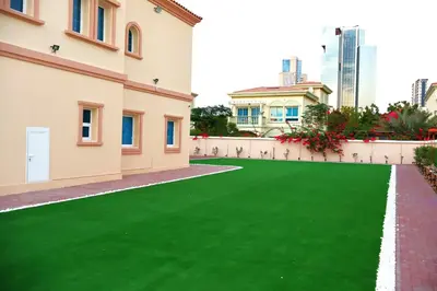 a green lawn in front of a building at Fully Furnished Garden Villa 2 Bedroom in Dubai