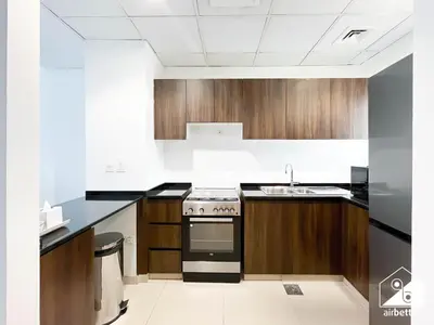 a kitchen with a stove and a sink at Luxury 3-Bedroom Duplex in Damac Hills & balcony in Dubai