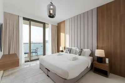 a bedroom with a large bed and a large window at Beach Isle 2, Emaar Beachfront - Mint Stay in Dubai