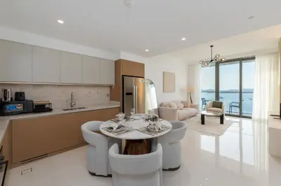 a kitchen and living room with a table and chairs at Beach Isle 2, Emaar Beachfront - Mint Stay in Dubai