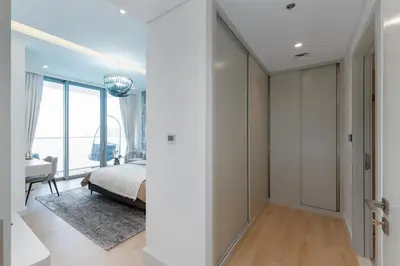 a bedroom with white walls and a bed and a desk at Beach Isle 2, Emaar Beachfront - Mint Stay in Dubai