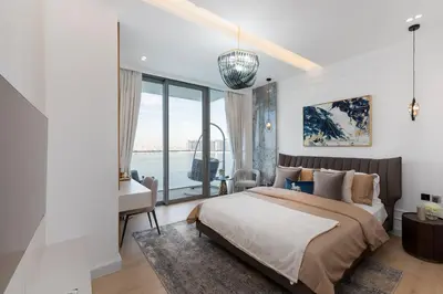 a bedroom with a bed and a desk and a window at Beach Isle 2, Emaar Beachfront - Mint Stay in Dubai