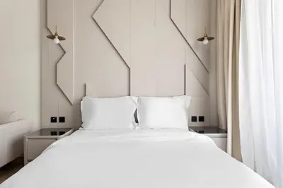 a white bed with white pillows in a bedroom at Cosy 1bedroom apartment with pool gym game room in Dubai