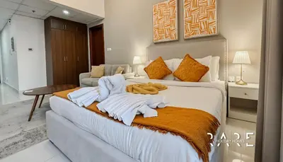 a hotel room with a bed with towels on it at Rare Holiday Homes - Dubai Sports City - Elite Residence - R1303 in Dubai