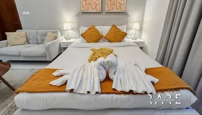 a bedroom with a bed with two towels on it at Rare Holiday Homes - Dubai Sports City - Elite Residence - R1303 in Dubai