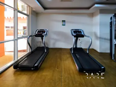 a gym with two treadmills in a room at Rare Holiday Homes - Jumeirah Village Circle - Near Circle Mall - Botanica Tower - R105 in Dubai
