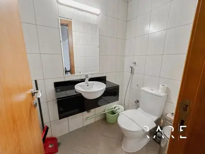 a bathroom with a white toilet and a sink at Rare Holiday Homes - Near Circle Mall - Lavender 1 - R309 - Jumeirah Village Circle in Dubai